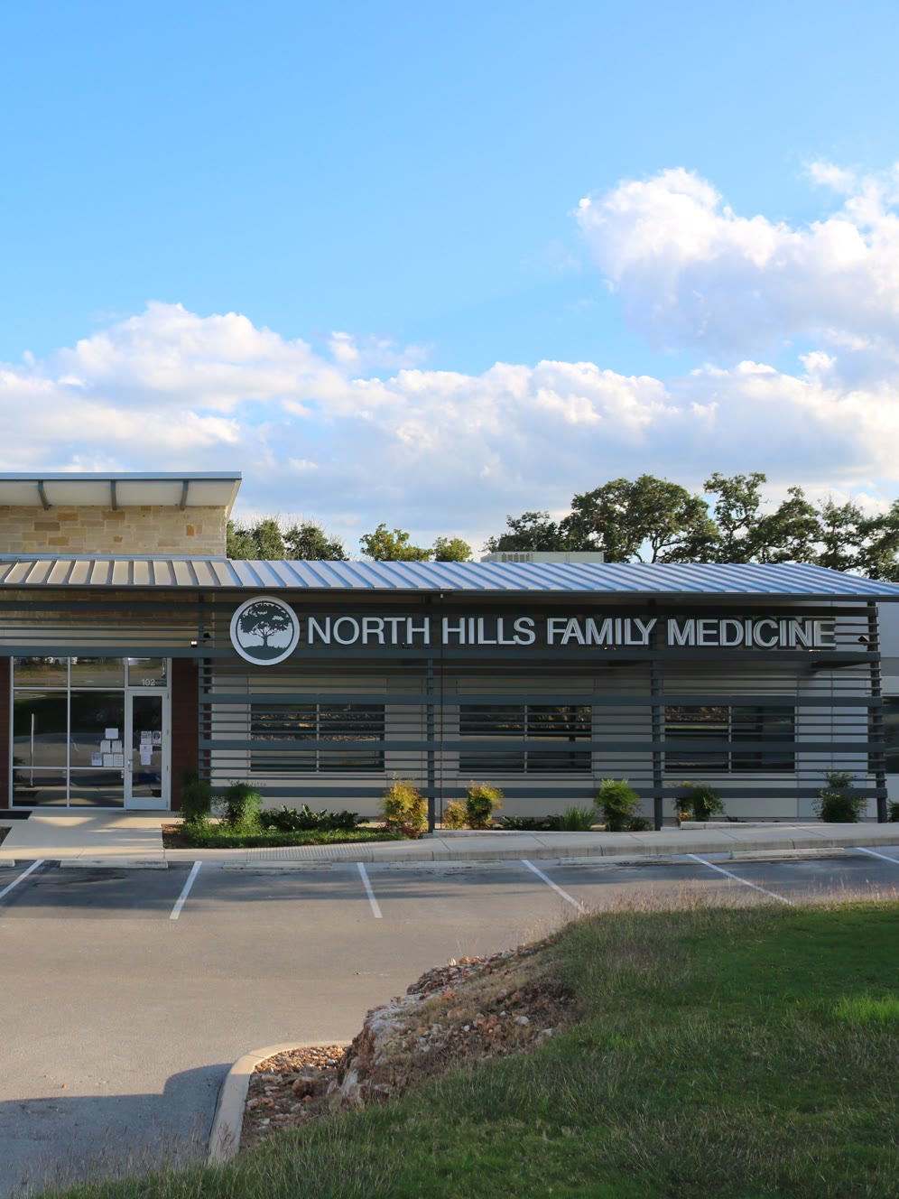 Exterior of the North Hills Family Medicine building with a parking lot in the foreground.