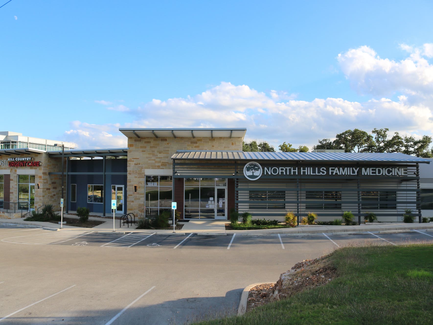 Exterior of North Hills Family Medicine and Hill Country Urgent Care medical office building with parking lot in the foreground.